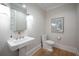 Chic powder room with a pedestal sink, classic fixtures, and elegant neutral décor at 3803 Palm Blvd, Isle of Palms, SC 29451