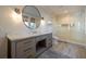 Bathroom showcasing a granite countertop vanity, round mirror, and a glass door shower at 3803 Palm Blvd, Isle of Palms, SC 29451