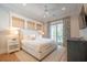 Bright bedroom with neutral colors, balcony access, ceiling fan, and woven window shades at 3803 Palm Blvd, Isle of Palms, SC 29451
