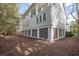 View of the side of the home shows crawl space and multiple windows on a large lot at 3803 Palm Blvd, Isle of Palms, SC 29451