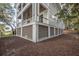 Three-story coastal home with ample storage space and decorative louvers along the bottom at 3803 Palm Blvd, Isle of Palms, SC 29451
