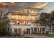 Elegant multi-story home with a manicured lawn, private gate and inviting facade at sunset at 3803 Palm Blvd, Isle of Palms, SC 29451