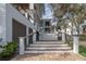 Exterior stairs featuring white railings and wood treads, with lush landscaping surrounding the home at 3803 Palm Blvd, Isle of Palms, SC 29451