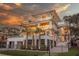 Magnificent coastal home with multi-level decks, soaring windows, and palm trees against a vibrant sky at 3803 Palm Blvd, Isle of Palms, SC 29451