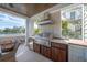 Outdoor kitchen with stainless steel grill, vent hood, granite countertops, and backyard views at 3803 Palm Blvd, Isle of Palms, SC 29451
