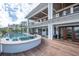 Inviting poolside retreat with wooden deck, lounge area and fireplace under a covered patio of an impressive home at 3803 Palm Blvd, Isle of Palms, SC 29451