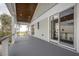 Expansive porch with gray floors, ocean view, light green walls, and multiple glass doors at 3803 Palm Blvd, Isle of Palms, SC 29451