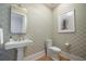 Stylish powder room with patterned wallpaper, pedestal sink, and elegant fixtures at 3803 Palm Blvd, Isle of Palms, SC 29451