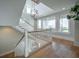 Staircase featuring wooden floors, white railings, large windows, and decorative light fixtures at 3803 Palm Blvd, Isle of Palms, SC 29451