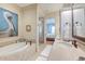 Bright bathroom features soaking tub, neutral tile, decoratives, and access to bedroom at 4247 Faber Place Dr # 5103, North Charleston, SC 29405