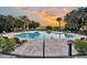 A stunning pool features comfortable lounge chairs and lush landscaping with palm trees and sunset at 4247 Faber Place Dr # 5103, North Charleston, SC 29405