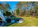 Backyard showcasing a fire pit with Adirondack chairs, and mature trees, providing a serene outdoor living space at 4281 Jacobs Point Ct, Ravenel, SC 29470