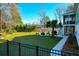 Fenced backyard featuring a fire pit area with Adirondack chairs, and a lush lawn, ideal for outdoor living at 4281 Jacobs Point Ct, Ravenel, SC 29470