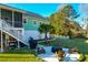 Elevated view of backyard with a cozy fire pit area, grill, mature trees, screened porch, and a fenced perimeter at 4281 Jacobs Point Ct, Ravenel, SC 29470