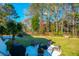 Lush backyard featuring a fire pit with Adirondack chairs, and a picturesque setting for outdoor enjoyment at 4281 Jacobs Point Ct, Ravenel, SC 29470