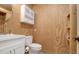 Compact bathroom featuring wood paneled walls, a white vanity, and toilet at 4281 Jacobs Point Ct, Ravenel, SC 29470