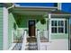 Inviting front porch with fern planters, outdoor seating, and a dark wood front door at 4281 Jacobs Point Ct, Ravenel, SC 29470