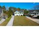 Aerial view of a green home with a long driveway and well-manicured lawn on a sunny day at 4281 Jacobs Point Ct, Ravenel, SC 29470