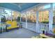 Relaxing screened porch with blue ceiling, yellow bench, and beautiful outdoor views at 4281 Jacobs Point Ct, Ravenel, SC 29470