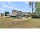 A backyard with an outdoor seating area, Adirondack chairs, an enclosed porch, and lush landscaping at 458 Four Seasons Blvd, Summerville, SC 29486