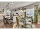 Dining area with a glass table, elegant chairs, and kitchen in the background at 458 Four Seasons Blvd, Summerville, SC 29486