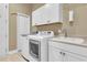 Functional laundry room with white cabinetry, a sink, and modern washer and dryer units at 458 Four Seasons Blvd, Summerville, SC 29486