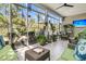 Inviting sunroom filled with natural light, green sofas, wicker furniture, and potted plants at 458 Four Seasons Blvd, Summerville, SC 29486