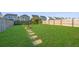 Large, well-manicured backyard with a fountain, stepping stones, and a wooden fence at 458 Whispering Breeze Ln, Summerville, SC 29486