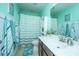 Bright teal bathroom with a striped shower curtain, single sink vanity, and modern accents at 458 Whispering Breeze Ln, Summerville, SC 29486