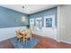 Inviting dining area features a wooden table with seating for four, accent wall, and wood floors at 458 Whispering Breeze Ln, Summerville, SC 29486