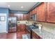 Well-equipped kitchen boasts stainless steel appliances, granite countertops, and dark wood cabinetry at 458 Whispering Breeze Ln, Summerville, SC 29486