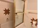Bathroom featuring unique star-shaped tile decor, a shower with glass doors, and a bathtub at 5310 Edith St, North Charleston, SC 29418