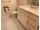 Bathroom with white vanity, modern sink and fixtures, decorative wall accents, and white tile floors at 5310 Edith St, North Charleston, SC 29418