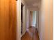 Hallway with hardwood floors, open doorways leading to other rooms, and white trim at 5310 Edith St, North Charleston, SC 29418
