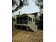 Back porch with railings and stairs surrounded by trees and leaves, offering a private outdoor space at 60 Fairway Dunes Ln, Isle of Palms, SC 29451