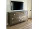 Bedroom dresser with detailed hardware and a television mounted above it at 60 Fairway Dunes Ln, Isle of Palms, SC 29451
