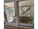 View through sliding glass doors to screened porch with wicker chairs and dining table and tree backdrop at 60 Fairway Dunes Ln, Isle of Palms, SC 29451