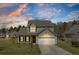 Inviting two-story home with a two car garage, manicured lawn, and picturesque evening sky at 629 English Oak Cir, Moncks Corner, SC 29461