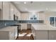 Bright kitchen featuring an island, white cabinets, stainless steel appliances, and wood-look flooring at 8703 Forte Dr, North Charleston, SC 29406