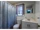 A functional bathroom featuring a toilet, sink, mirror, and a shower with a patterned blue curtain at 105 Wade Ct, Summerville, SC 29486