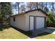 Single-story detached garage with beige siding, and a white door, providing ample storage and parking at 105 Wade Ct, Summerville, SC 29486