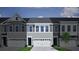 Gray townhome featuring a two-car garage, gray siding, and a covered front porch entrance at 108 Brown Swiss Cir, Summerville, SC 29483