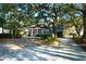 Charming brick home featuring a welcoming front porch and beautifully landscaped yard with mature trees at 10812 Dorchester Rd, Summerville, SC 29485