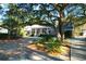 Charming brick home featuring a welcoming front porch and beautifully landscaped yard with mature trees at 10812 Dorchester Rd, Summerville, SC 29485