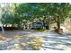 Charming brick home featuring a welcoming front porch and beautifully landscaped yard with mature trees at 10812 Dorchester Rd, Summerville, SC 29485