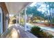 Inviting brick home with a classic front porch, white columns, and well-manicured landscaping at 10812 Dorchester Rd, Summerville, SC 29485