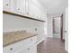 Mud room features white cabinets with granite countertops and wood-look flooring at 10812 Dorchester Rd, Summerville, SC 29485