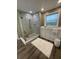 Stylish bathroom featuring a glass-enclosed shower, soaking tub, white stool, and wood-look flooring at 112 Amanda Cir, Goose Creek, SC 29445