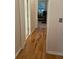Hallway with hardwood floors leading to an office space with a desk, chair, and natural light at 112 Amanda Cir, Goose Creek, SC 29445