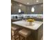 A kitchen island with a sink and bar seating sits beneath pendant lights, next to stainless steel appliances at 112 Amanda Cir, Goose Creek, SC 29445